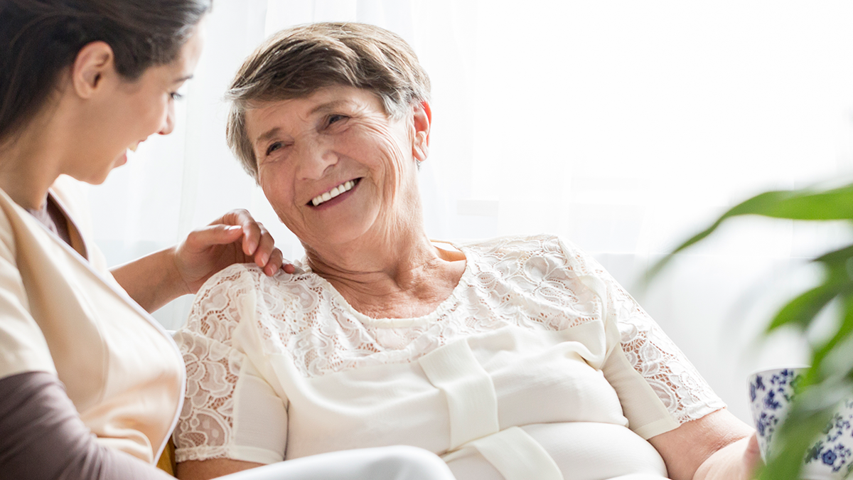 Senior with Alzheimer's disease getting help from a caregiver